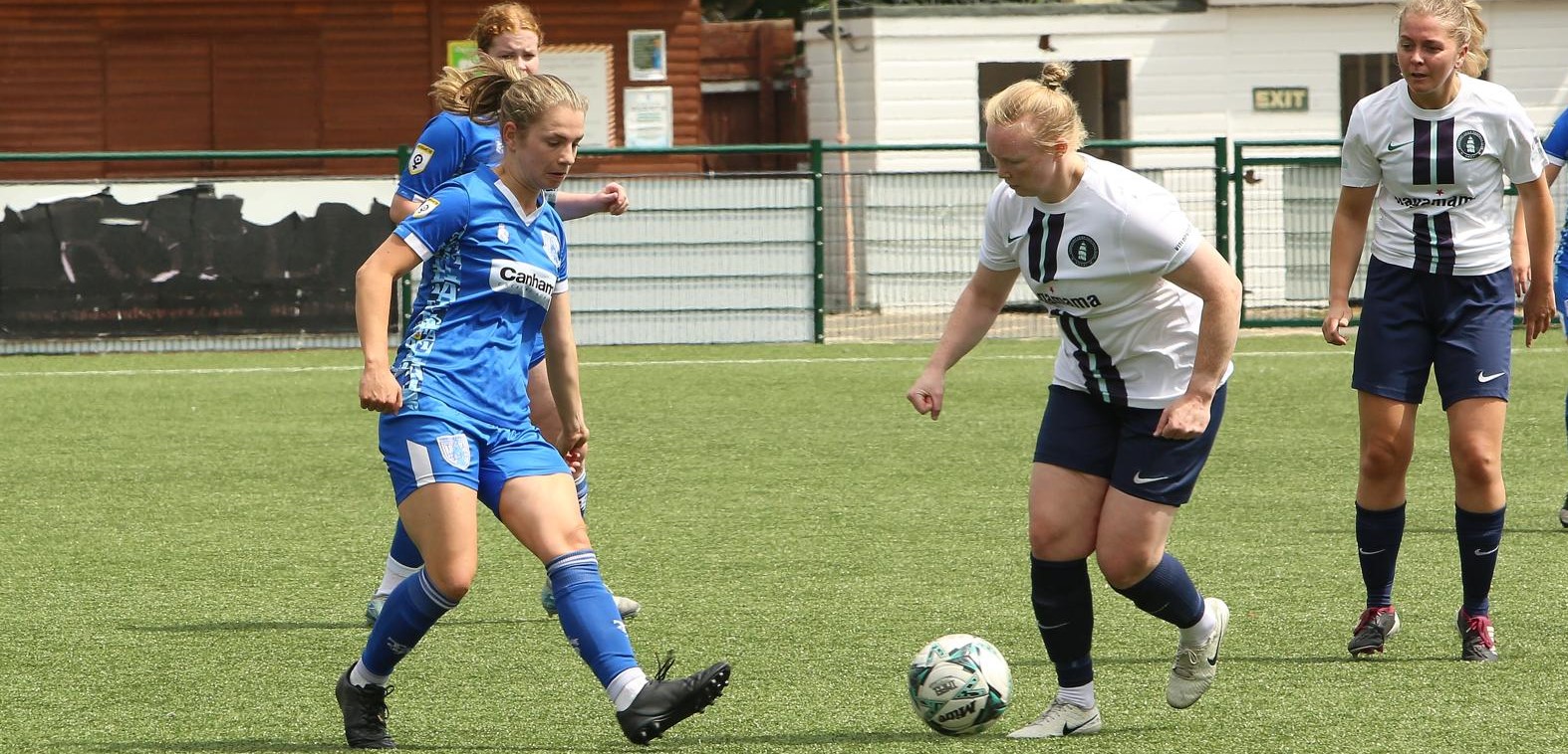 Tonbridge Angels Women FC player making a tackle during a match — the type of explosive movement that commonly causes hamstring and groin injuries