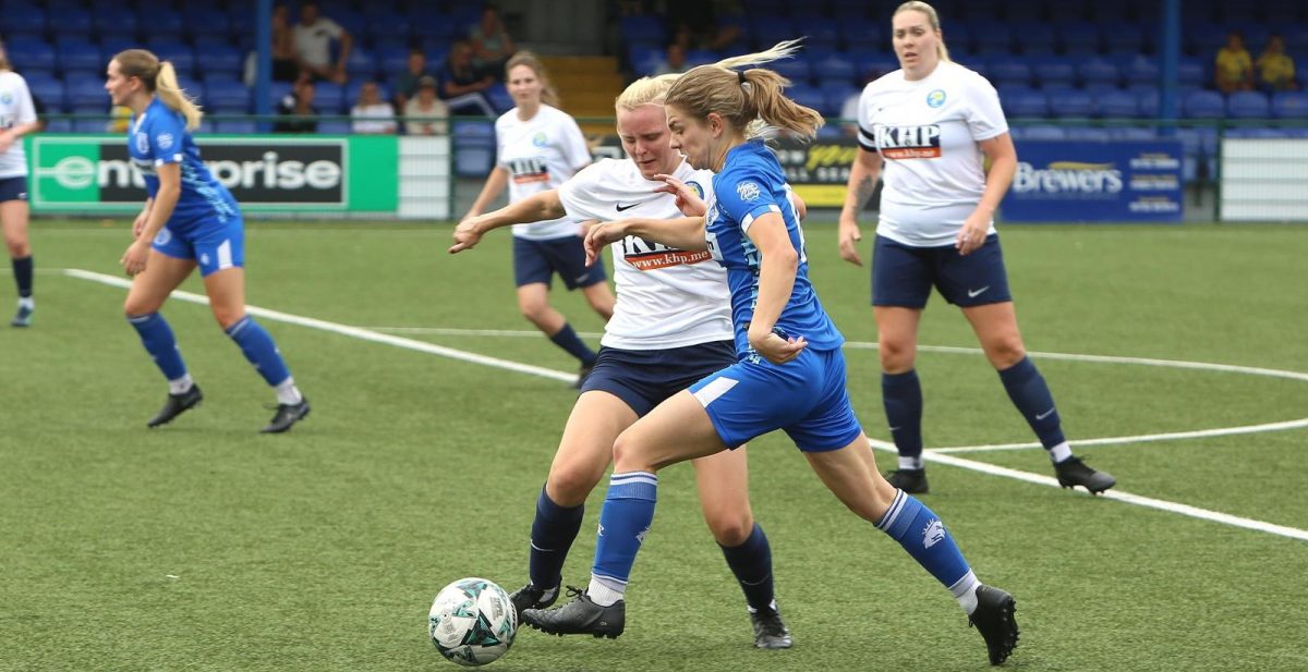 Two players competing for the ball in a physical challenge during a Tonbridge Angels Women FC match — a common cause of knee and ankle sprains